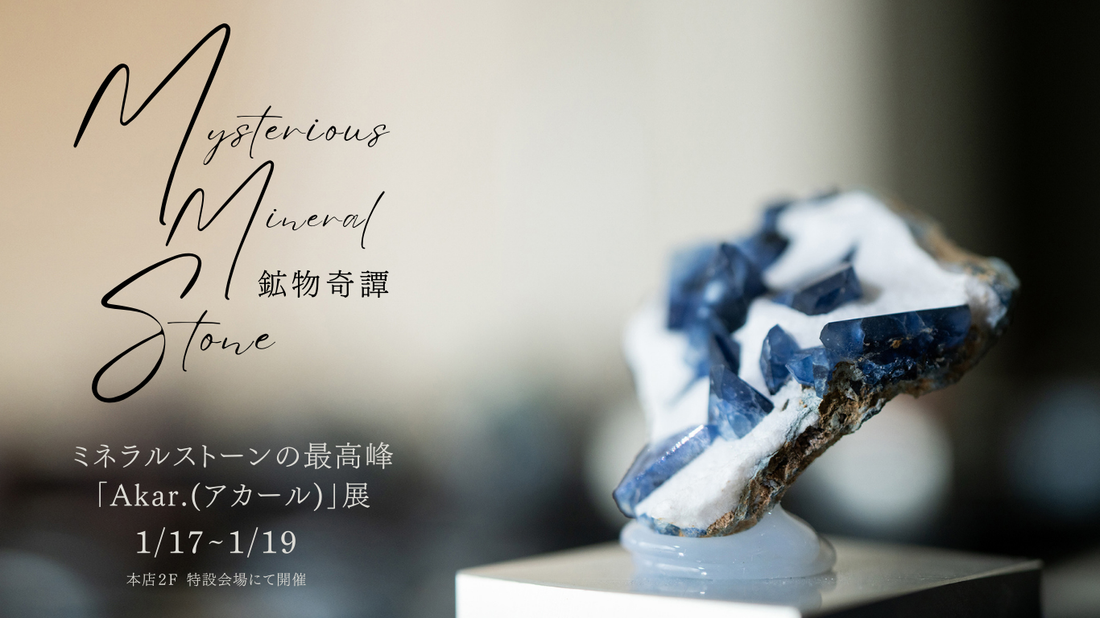 白い岩の上に青い結晶が連なる鉱物を台に置いた写真に、「Mysterious Mineral Stone 鉱物奇譚」「ミネラルストーンの最高峰「Akar.(アカール)」展 1/17~1/19 本店2F 特設会場にて開催」の文字を重ねたバナー